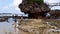 Tourists playing in the water on the beach which has sharp coral and white sand