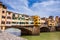 Tourists at Ponte Vecchio a medieval stone closed-spandrel segmental arch bridge over the Arno