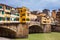 Tourists at Ponte Vecchio a medieval stone closed-spandrel segmental arch bridge over the Arno