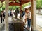 Tourists purifying themselves at Temizuya washing station before entering KÅtoku-in the great buddha temple in Japan