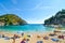 Tourists relax in the clear waters at the sandy Palaiokastritsa beach and bay on the Aegean island of Corfu, Greece