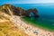 Tourists Relaxing On Durdle Door Beach, Dorset