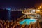 Tourists relaxing near a swimming pool at night