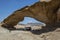 Tourists rest under the shade of the Bridge in Wadi Rum in Jordan.