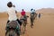 Tourists ride camels into Erg Chebbi at Merzouga in Morocco.