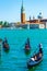 Tourists ride gondolas on turquoise waters Venice lagoon