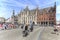 Tourists riding a bike close to the Provinciaal Hof in the Market Square of Bruges