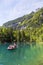 Tourists riding in boat at Blausee or Blue Lake nature park in summer, Kandersteg, Switzerland