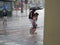 Tourists run under summer storm shower blurred motion effect