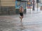 Tourists run under summer storm shower blurred motion effect