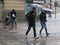 Tourists run under summer storm shower blurred motion effect