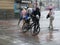 Tourists run under summer storm shower blurred motion effect
