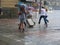 Tourists run under summer storm shower blurred motion effect