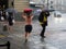 Tourists run under summer storm shower blurred motion effect