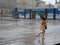 Tourists run under summer storm shower blurred motion effect