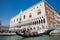 Tourists sailing in a gondola on the Grand Canal in Venice in front of the Doge Palace