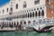 Tourists sailing in a gondola on the Grand Canal in Venice in front of the Doge Palace