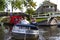 Tourists sailing on rented boats on the canal between houses in the famous village of Giethoorn. The village is called the Venice