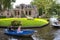 Tourists sailing on rented boats on the canal between houses in the famous village of Giethoorn. The village is called the Venice