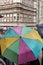 Tourists shelter beneath colorful umbrellas
