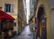 Tourists shop a very narrow alley full of cafes and shops in the Old Town of Vieux Nice, France, on the French Riviera