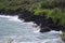 Tourists sight seeing on the black sand beach and trails of Waianapanapa State Park, Maui, Hawaii