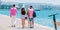 Tourists sightseeing a city while walking on a boardwalk on a sunny summer day