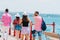 Tourists sightseeing a city while walking on a boardwalk on a sunny summer day