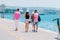 Tourists sightseeing a city while walking on a boardwalk on a sunny summer day