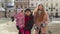 Tourists sisters couple with younger sister child girl walking in city, talking with smiles outdoor