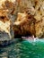 Tourists on a small boat exploring the many caves and grotto around the coast of Lagos, Portugal