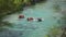Tourists splash water sailing boats along mountain river