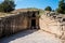 Tourists stainding at the entrance of Treasury of Atreus, Peloponnese, Greece.