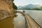 Tourists stand at the bamboo pier next to the Tham Ting cave with over 4000 Buddha figures in Luang Prabang, Laos