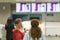 Tourists stand in front of an information Board in the interior of the airport. Blur image of people waiting in front of airport