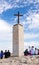 Tourists stand on the viewpoint, inspect the neighborhood and photograph the border cross belonging to the monastery of St. George