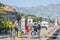 Tourists with suitcases, backpack and bags walk along the yachts and motorboats moored at the pier