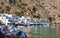 Tourists sunbathing and swimming in blue lagoon of Loutro town at Crete island