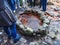 Tourists surrounded a shallow stone well filled with mineral water. Healing mineral spring of the Narzans valley