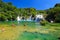 Tourists swim in the lake near picturesque cascade waterfall in the Krka National Park, Croatia in summer. The best big beautiful