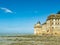 Tourists take a break in the beach surrounding Le Mont Saint Michel during low tide, Normandy, Northern France