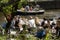 Tourists take a drink in the sun on the terrace of a cafe on the banks of a canal in Amsterdam