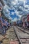 Tourists take photo at the train running through the most popular spot Talad Rom Hup or Umbrella market at Mae Klong railway