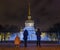 Tourists take pictures of the night city and fountain with lighting. Spire of Admiralty, St. Petersburg, Russia