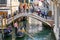 Tourists taking gondola, the traditional Venetian boat, on canal in Venice, Italy