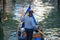 Tourists taking gondola, the traditional Venetian boat, on canal in Venice, Italy