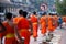 Tourists taking photos Laos Buddhist Monks with buddhist alms giving ceremony on the road in the morning, traditional of giving