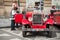 Tourists talk with a driver of red oldtimer car