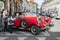 Tourists talk with driver of red oldtimer car