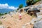 Tourists on a tour of an ancient antique cemetery. The entrance to old concrete tomb in rock. historical monument of